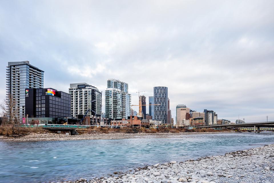 Calgary skyline at sunset with the Bow River and Canadian Rockies in the distance