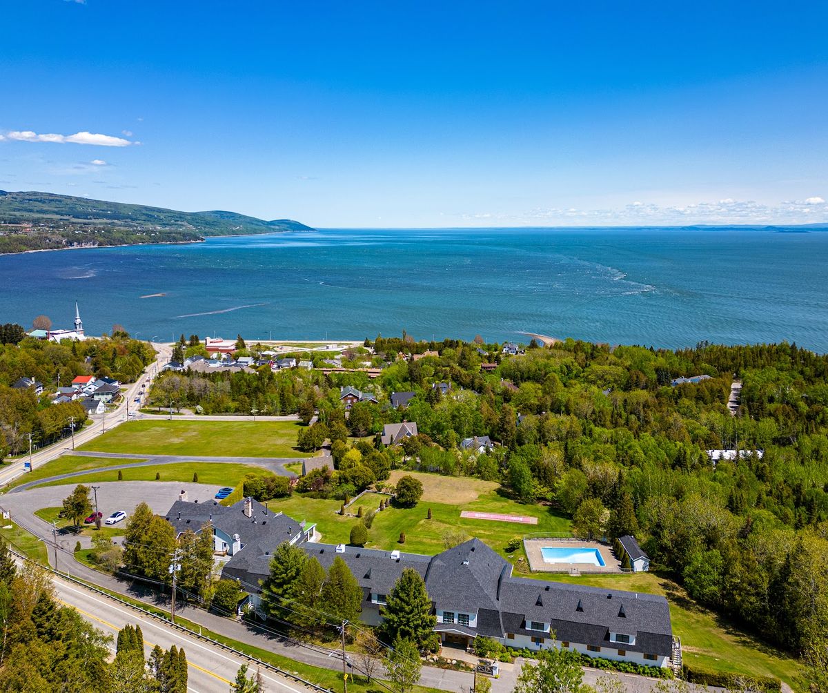 Charlevoix Quebec — Fairmont Le Manoir Richelieu castle perched on St. Lawrence River cliffs at dusk