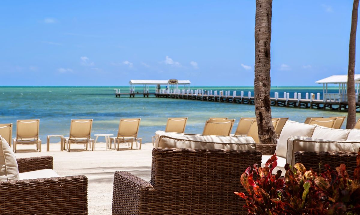 The Moorings Village & Spa Islamorada — boutique cottages and private white sand beach with palm trees
