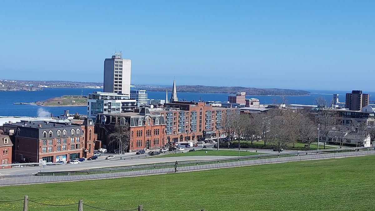 Halifax Harbour at dusk — sailboats moored along the Waterfront Boardwalk with Citadel Hill above the downtown skyline