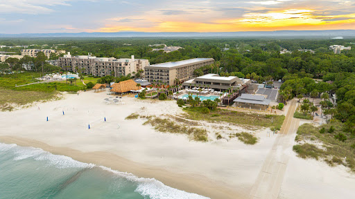 Hilton Head Island beach at golden hour — wide Atlantic shoreline framed by sea oats and palmetto