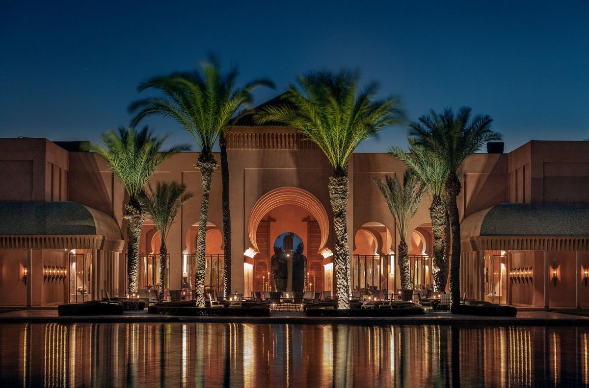 Marrakech riad courtyard at golden hour — traditional zellige tilework, fountain and orange trees, Morocco