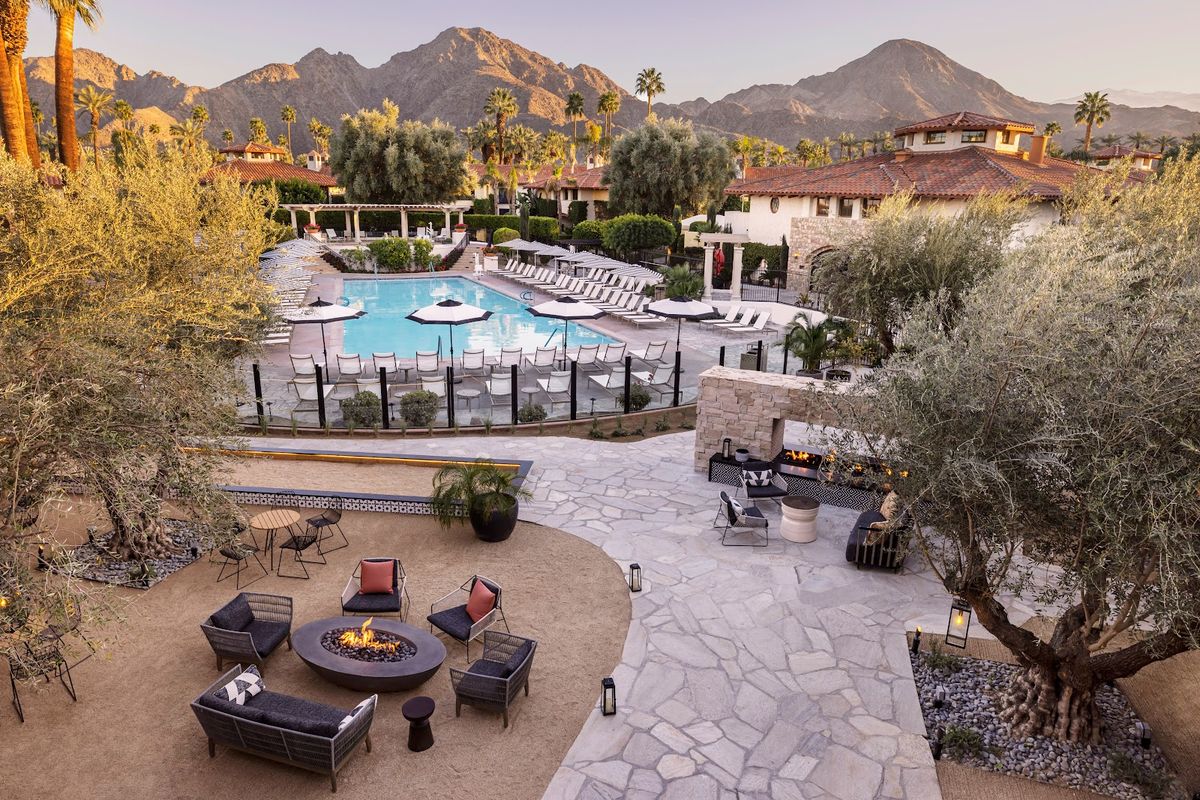 The Saguaro Palm Springs — rainbow-painted hotel facade with poolside crowd and DJ during Coachella weekend
