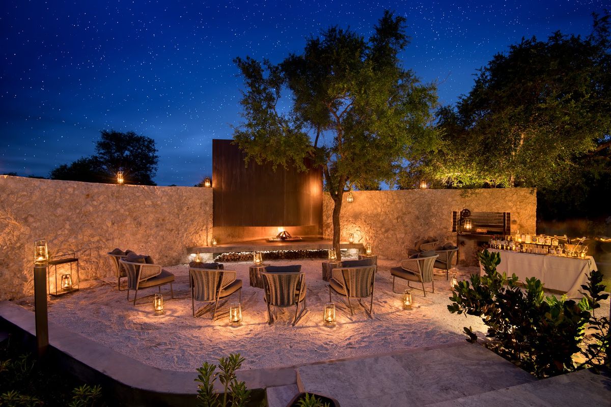 Sabi Sand Game Reserve sunset — leopard on rock outcrop with bush savannah, South Africa premier safari destination